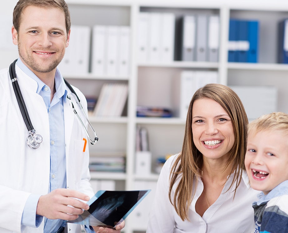 Male doctor checking in with mother and son