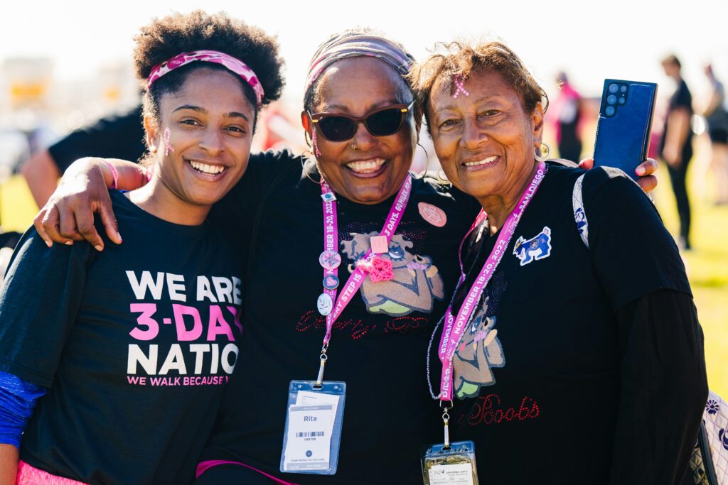 three women embracing and posing for a photo at a Susan G Komen Race for The Cure marathon